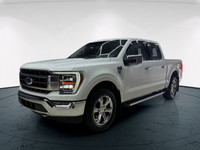 The 2021 Ford F-150 Lariat, clad in a stunning white coat and equipped with a robust 4x4 drivetrain,... (image 1)