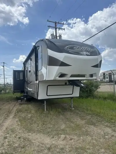 The rear entertainment layout of this Keystone Cougar fifth wheel makes it feel a lot like home. Mod...