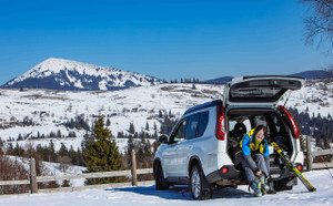 Meilleures SUV compacts - Femme enfile des chaussures de ski à la montagne