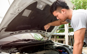 Man checking oil of car