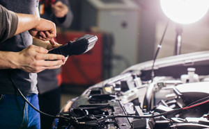 Mechanic inspecting car battery