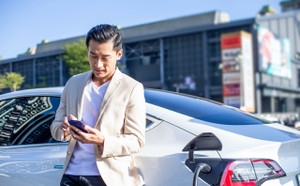 Electric Sport Sedan - Man using smartphone while phone is charging