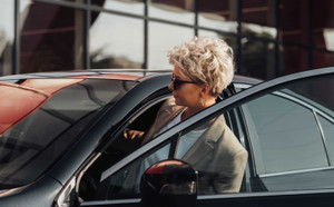 Elegant Woman Driver Getting in the Luxury Car