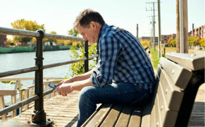 Man sitting on a bench looking at his phone