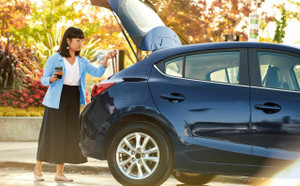 Lady putting her handbag into the trunk of her car