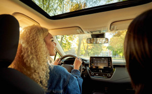 Young driver checking her rear view mirror