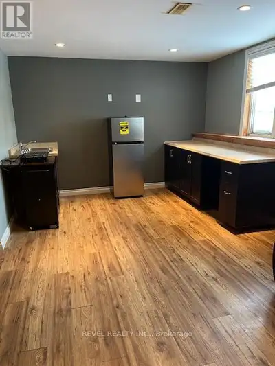 This lower-level apartment features a bright kitchen with a refrigerator, double-burner hotplate, an...