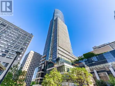 Live above it all in this furnished corner suite on the 71st floor at Aura Condominiums! Featuring b...