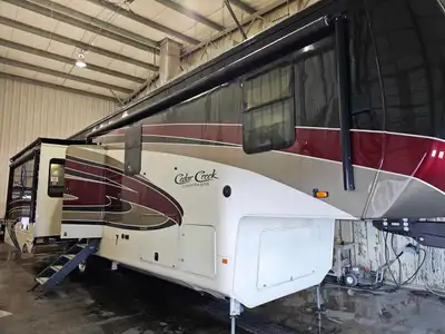 This exquisite pre-owned 2020 Cedar Creek Champagne 38EL luxury fifth wheel, recently traded in, off...