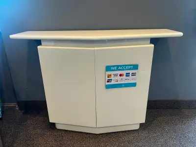Small white table. unique shape design. It was used to display information and products at an office...