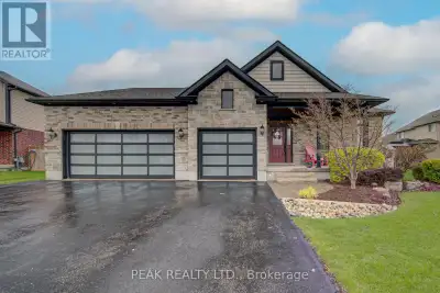This stunning brick and stone custom home offers exceptional curb appeal and is located in one of Ta...