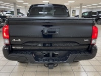 The black paint drinks in daylight like ink, casting sharp reflections across muscular fenders while... (image 4)