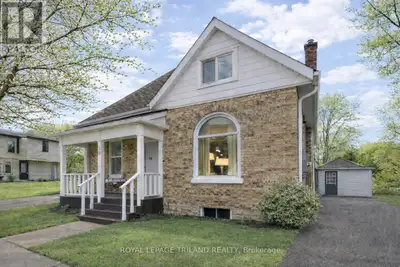 Charming yellow brick home with a welcoming covered front porch, ideally located just a short walk f...