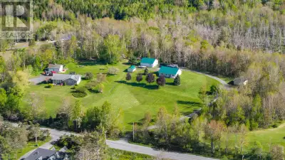 Tucked behind a canopy of trees at the end of a winding driveway, this thoughtfully designed bungalo...