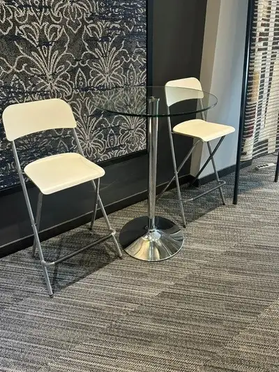 Glass top coppa table with 2 white folding chairs, View more