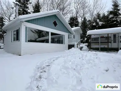 Cuisinette trois saisons, roulotte de voyage et deux remises sur un terrain surélevé avec une belle...