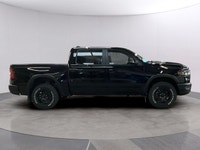 The 2026 Ram 1500 Rebel 4x4 Crew Cab in a striking black hue offers a commanding presence on any ter... (image 5)