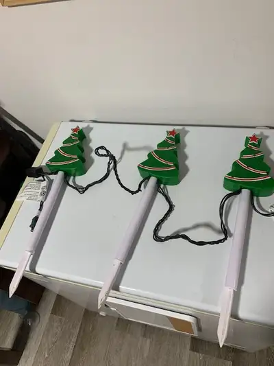 Selling a set of 3 plugin outdoor Christmas tree shaped decorations that light up. They do not play...