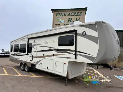 This triple slide Cedar Creek 36CKTS Fifth Wheel by Forest River offers spacious living accommodatio...