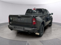 The 2026 Ram 1500 Rebel 4x4 Crew Cab in a striking black hue offers a commanding presence on any ter... (image 4)