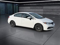 The 2014 Honda Civic Sedan LX, in a pristine white finish and equipped with a smooth front-wheel-dri... (image 1)