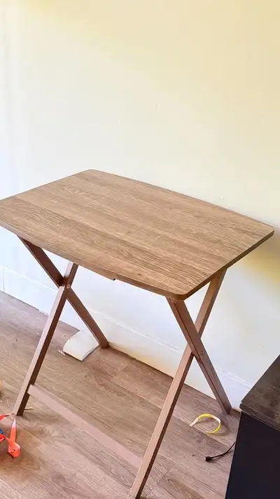 Selling a wooden folding table in good condition. It has a clean wood-finish tabletop and foldable l...