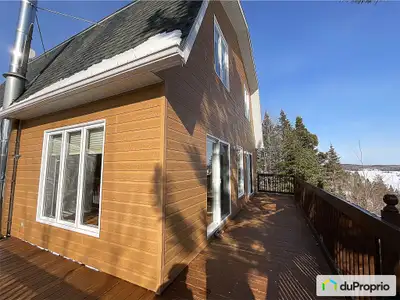 Maison à toit mansardé au bord du lac Kénogami avec vue panoramique et orientée vers le sud-ouest. P...