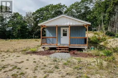 This charming cabin features board and batten siding , a durable metal roof and a covered deck overl...