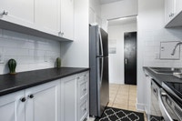 Fully renovated spacious suite features kitchen with modern features and finishes including laminate... (image 1)