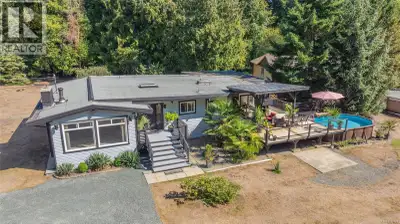 Welcome to this private, sunny 5-acre estate located just steps from Englishman River Falls, offerin...