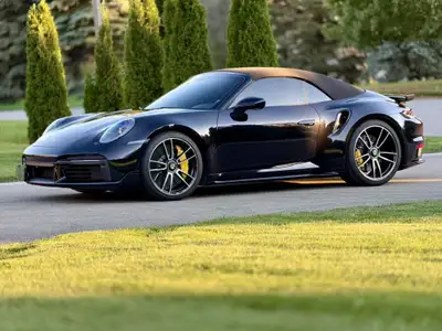 2023 Porsche 911 Turbo S Cabriolet with very low kilometers! The metallic black exterior and vibrant...