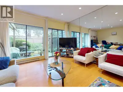 Spacious sunken living room, woodburning fireplace, hardwood and tile floors, luxurious green plants...