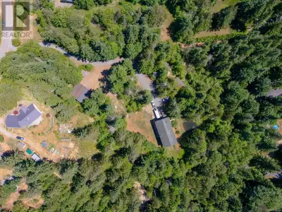 Tucked away on a quiet and usable 3.26-acre property near the scenic Qualicum River Falls, 1890 Pier...