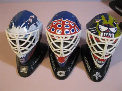 Three goalie masks. Leafs, Canadiens, Panthers.