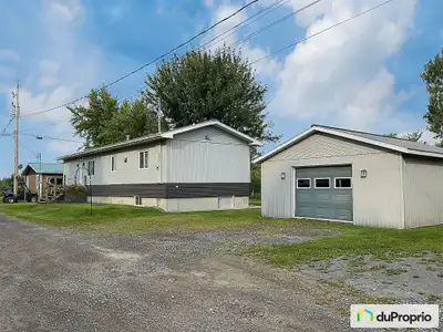 Grand terrain intime, avec vue sur le lac St-François et grand garage avec annexe. Niché dans un cad...
