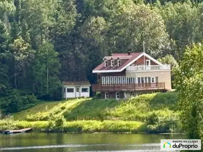 Une maison unifamiliale située en forêt sur le bord d'un lac à 7 minutes seulement de la ville, des...