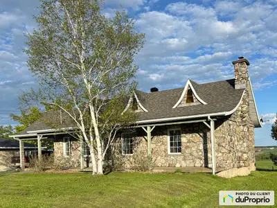 Jolie maison chaleureuse en pierre de champs sur trois murs et un en brique avec un carport, bien en...