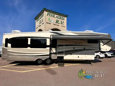 This triple slide Cedar Creek 36CKTS Fifth Wheel by Forest River offers spacious living accommodatio...