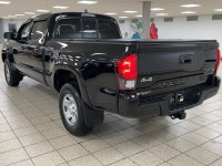 The black paint drinks in daylight like ink, casting sharp reflections across muscular fenders while... (image 3)