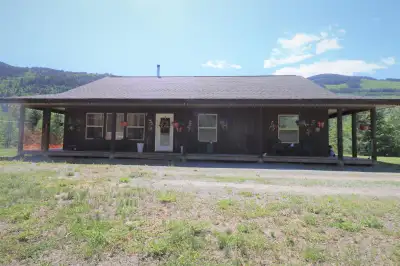 Nestled on a sprawling 19.62-acre lot with river frontage, this custom-built rancher offers a harmon...