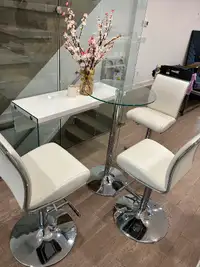 High top glass table and white leather swivel chairs