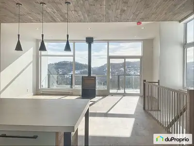 Ce condo intégré en flanc de montagne aux abords de la piste de ski du Boulevard de la Station Touri...