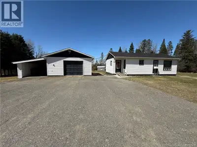 Cozy bungalow situated on an acre, featuring a detached garage and multiple sheds for added storage...