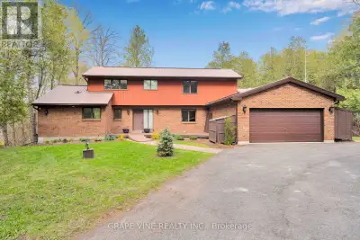 Rare Ottawa River waterfront home in Woodlawn, set behind a gated brick-and-iron entrance on a deep,...