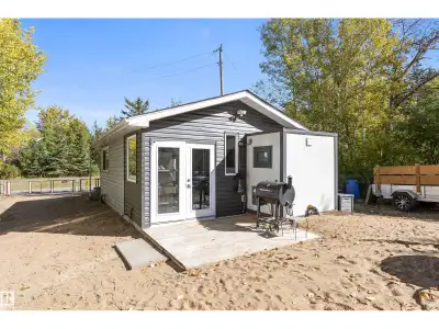 Nestled on a quiet corner lot surrounded by trees & just steps from the lake, this charming TINY HOM...