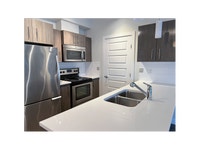 Each suite includes a stainless-steel fridge, stove, dishwasher, and microwave by Whirlpool, as well... (image 2)