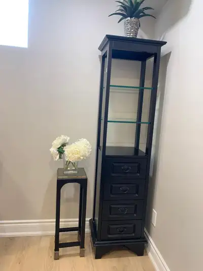 Tall skinny display cabinet with glass shelves and drawers, View more