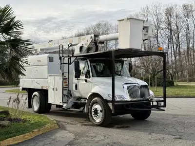 This 2011 International 4300 bucket chipper truck is powered by a 7.6L inline-6 paired with an Eaton...