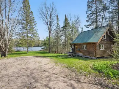 Nestled along 214 feet of pristine Leslie Lake waterfront, this charming round log Bunkie offers 320...