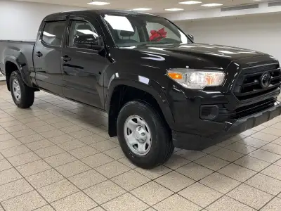 The black paint drinks in daylight like ink, casting sharp reflections across muscular fenders while...